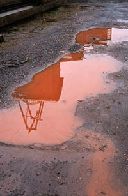Reflection of pithead in rust puddle